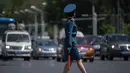 Seorang polisi wanita berada ditengah jalan untuk mengatur lalu lintas di Pyongyang, Korea Utara (5/6). Di Korea Utara menjadi polisi lalu lintas dipandang sebagai pekerjaan yang bergengsi. (AFP Photo/Ed Jones)