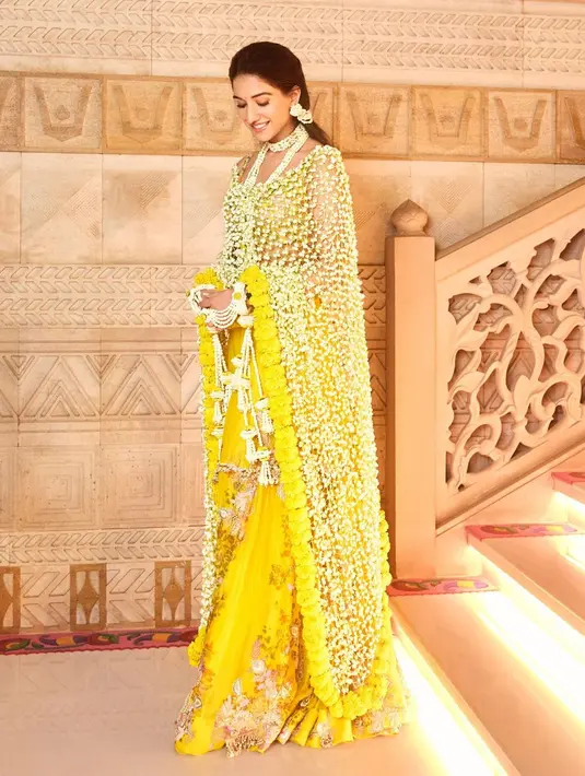 Di acara Haldi yang seperti siraman, Radhika Merchant tampil mengenakan long shawl dari ronce bunga asli. Long shawl ini terbuat dari bunga Sogra dan Marigold. [Foto: Instagram/rheakapoor]