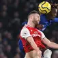 Striker Chelsea, Tammy Abraham, berebut bola dengan bek Arsenal, Shkodran Mustafi, pada laga Premier League pekan ke-24 di Stamford Bridge, London, Rabu (22/1). Arsenal tahan imbang Chelsea 2-2. (AFP/Daniel Leal-Olivas)