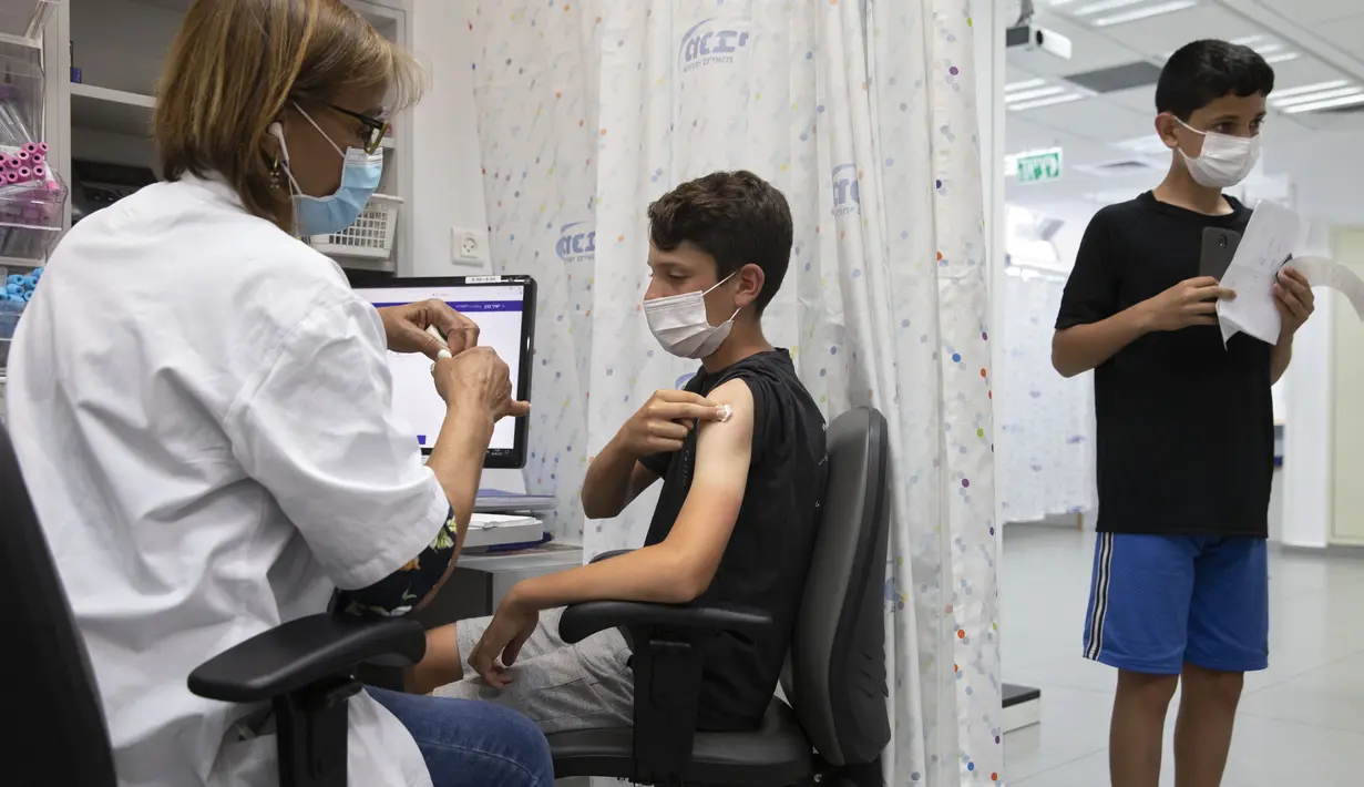 Seorang remaja Israel menerima vaksin COVID-19 Pfizer-BioNTech di kota Rishon LeZion, Minggu (6/6/2021). Israel mulai memvaksinasi anak-anak dari usia 12 hingga 15 pada hari Minggu. (AP Photo/Sebastian Scheiner)