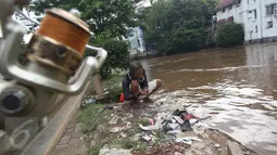 Warga mempersiapkan umpan sebelum memancing di bantaran Sungai Ciliwung, Jakarta, Selasa (21/2). Meluapnya Sungai Ciliwung menjadi berkah tersendiri bagi warga untuk memancing dan menjala ikan yang terbawa arus dari hulu. (Liputan6.com/Immanuel Antonius)