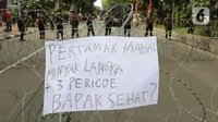 Sebuah poster diletakkan pada kawat berduri yang menjadi barikade saat aksi demo mahasiswa di kawasan Patung Kuda, Jakarta, Senin (4/11/2022). Mereka menyampaikan tuntutannya terkait kenaikan minyak goreng dan bahan bakar minyak (BBM). (Liputan6.com/Herman Zakharia)