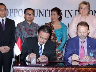 Kepala Bakamla Desi Albert Mamahit (duduk kiri) dan Dubes Norwegia untuk Indonesia Stig Traavik (duduk kanan) menandatangani kesepakatan kerja sama dalam bidang kelautan dan perikanan di Jakarta, Selasa (14/4/2015). (Liputan6.com/Helmi Afandi)