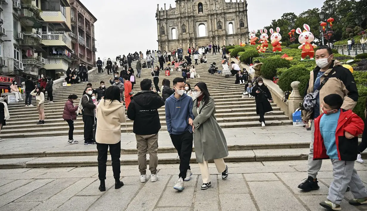 Pelancong asal China berjalan-jalan di daerah kantong China, Makau, 17 Januari 2023. Ledakan pariwisata China yang diharapkan selama liburan Tahun Baru Imlek minggu depan tampaknya akan lebih cepat terjadi. (Peter PARKS/AFP)