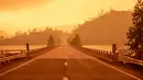 Langit berubah menjadi oranye gelap saat asap memenuhi wilayah kebakaran hutan yang dijuluki Carr Fire di Whiskeytown, California, Jumat (28/7). Bencana yang melanda California akibat gelombang panas di negara bagian itu. (JOSH EDELSON/AFP)