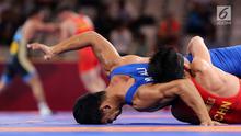 Pegulat China Zhang Gaoquan mengunci Muhammad Aliansyah dari Indonesia saat bertarung pada kelas putra 67 Kg Asian Games 2018 di arena gulat JCC Senayan, Selasa (21/8). Aliansyah kalah atas lawanya dengan skor 0-7. (Liputan6.com/Fery Pradolo)