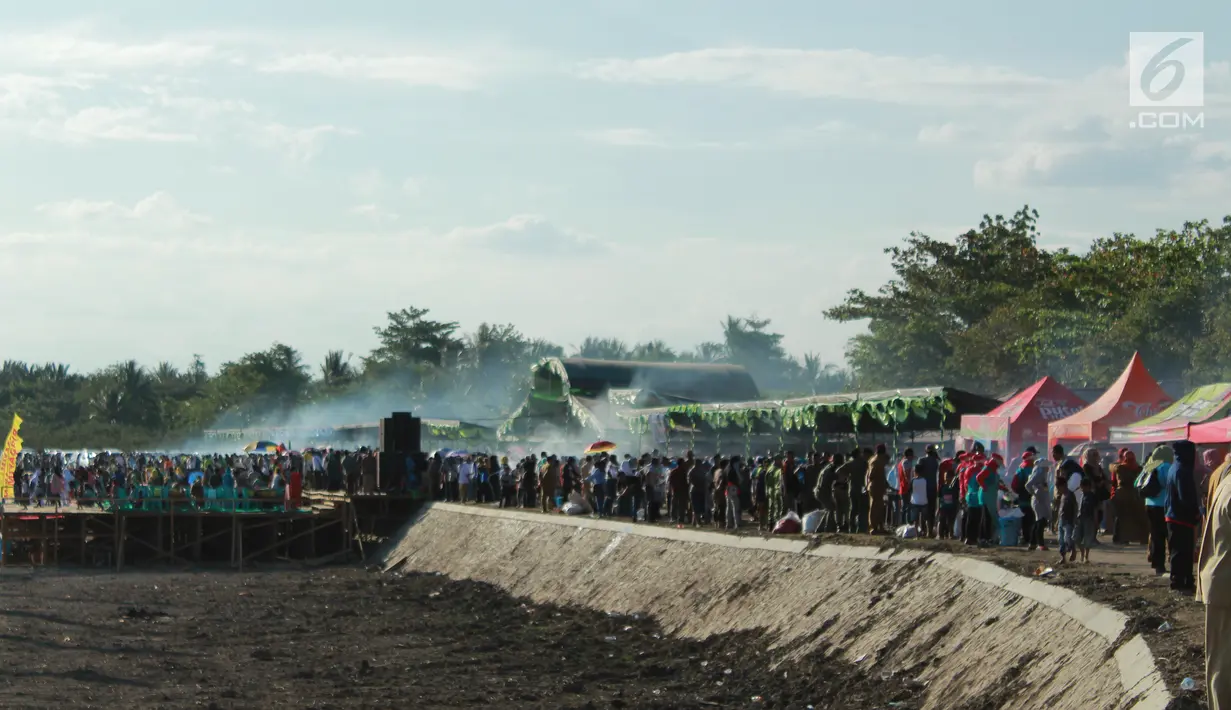 Masyarakat memadati lokasi pemecahan rekor sajian sate terbanyak di tepi Danau Limboto, Gorontalo, Senin (24/9). MURI mencatat sebanyak 88.950 tusuk sate berhasil memecahkan rekor dunia untuk sajian sate terbanyak. (Liputan6.com/Arfandi Ibrahim)