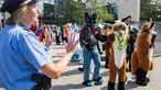 Peserta mengenakan kostum binatang berinteraksi dengan polisi saat parade konvensi Eurofurence di Berlin, Jerman (17/8). Sekitar 2700 delegasi dari berbagai negara ikut berpartisipasi dalam acara tersebut. (AFP Photo/Ganjil Andersen)