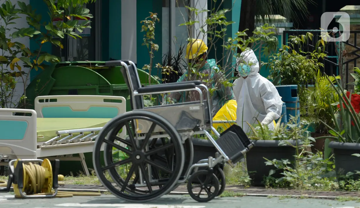 Petugas kesehatan memakai baju APD sedang membersihkan sampah bekas medis di Puskesmas Pamulang, Kecamatan Pamulang, Tangerang Selatan, Banten, Senin (13/04/2020). Sampah bekas medis tes Covid-19 tersebut akan dimusnahkan guna untuk mensteril kawasan puskesmas. (merdeka.com/Dwi Narwoko)