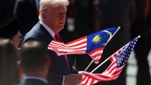 Presiden Donald Trump mengangkat bendera Malaysia dan Amerika Serikat dalam upacara penyambutan setibanya di Bandara Internasional Kuala Lumpur, Minggu (26/10/2025) untuk menghadiri KTT ke-47 ASEAN. (Dok. Hasnoor Hussain/Pool Photo via AP)&nbsp;&nbsp;&nbsp;