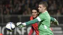 Kiper Angers, Ludovic Butelle (kanan) berebut bola dengan pemain Paris Saint-Germain, Edinson Cavani pada lanjutan Ligue 1 di Stadion Jean Bouin, Angers, France. (AFP Photo/Damien Meyer)