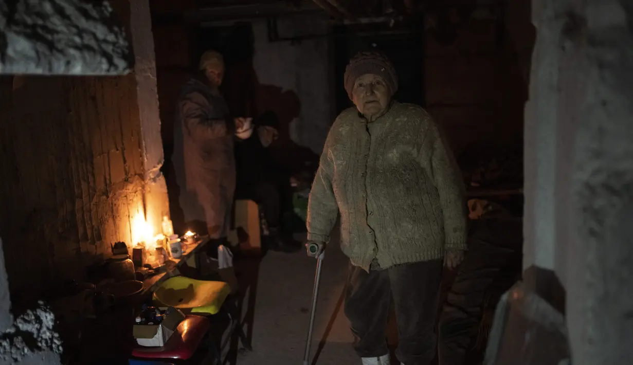 Seorang wanita tua bersiap untuk makan siang di ruang bawah tanah sebuah bangunan yang digunakan sebagai perumahan bagi sekitar 400 orang, karena apartemen digunakan oleh tentara Rusia selama pendudukan Bucha, di pinggiran Kyiv, Ukraina, Senin, 4 April 2022 (AP Photo/Rodrigo Abd)