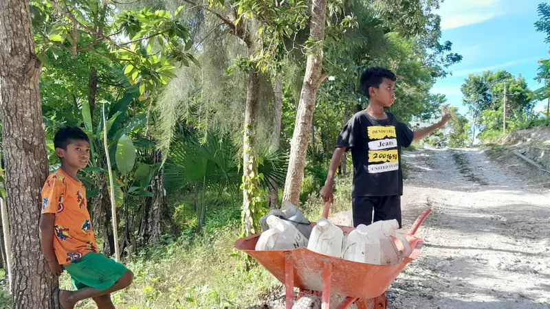 Anak dari Desa Basmuti, Kecamatan Kuanfatu, Kabupaten Timor Tengah Selatan, Nusa Tenggara Timur (NTT) usai pulang mengambil air bersih dari kran dekat rumah. (Foto: Liputan6com/Benedikta Desideria)