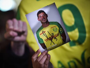 Mantan bintang FC Nantes, Emiliano Sala dikabarkan meninggal dunia usai pesawat yang ditumpanginya hilang dari kontak, selasa (22/1). Hal tersebut membuat pendukung FC Nantes larut dalam rasa duka. (AFP/Loic Venance)