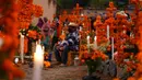 Kerabat bersiap untuk bermalam di samping makam tercinta pada perayaan Hari Kematian di pemakaman Arocutin, Michoacan, Meksiko, 1 November 2021. Tradisi ini bertepatan dengan Hari Semua Orang Kudus dan Hari Semua Jiwa. (AP Photo/Eduardo Verdugo)