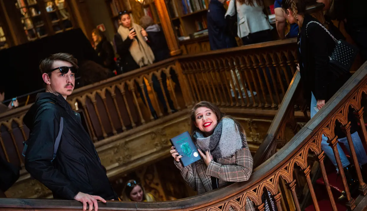 Seorang wanita memegang buku Harry Potter di toko buku Lello, Porto, Portugal, Sabtu (12/1). Toko buku Lello diduga menginspirasi JK Rowling untuk menulis Harry Potter. (MIGUEL RIOPA/AFP)