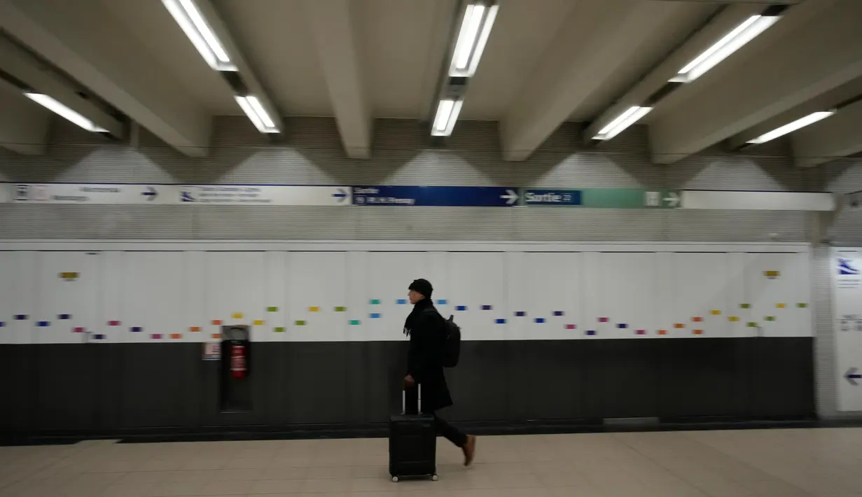Seorang pria berjalan di koridor stasiun kereta bawah tanah, Paris, Prancis, Selasa (7/2/2023). Usulan Presiden Emmanuel Macron terkait penundaan usia pensiun memicu pemogokan dan demonstrasi besar-besaran dalam beberapa pekan terakhir. Rancangan undang-undang ini akan menaikkan usia pensiun minimum dari 62 menjadi 64 tahun. (AP Photo/Christophe Ena)