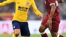 Penyerang Atletico Madrid, Antoine Griezmann berusaha membawa bola dari hadangan penyerang Roberto Firmino pada final Audy Cup di Munchen, (2/8). Atletico menang 5-4 atas Liverpool lewat adu penalti setelah bermain imbang 1-1. (AFP Photo/Christof Stache)