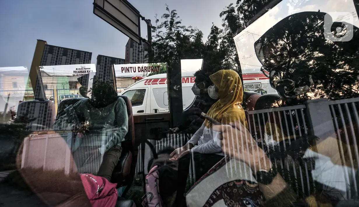 Pasien Covid-19 berada di dalam bus sekolah di RSD Wisma Atlet Kemayoran, Jakarta, Kamis (10/6/2021). Meningkatnya jumlah warga yang terpapar Covid-19 menyebabkan antrean ambulans yang hendak masuk ke RSD Wisma Atlet Kemayoran. (merdeka.com/Iqbal S. Nugroho)