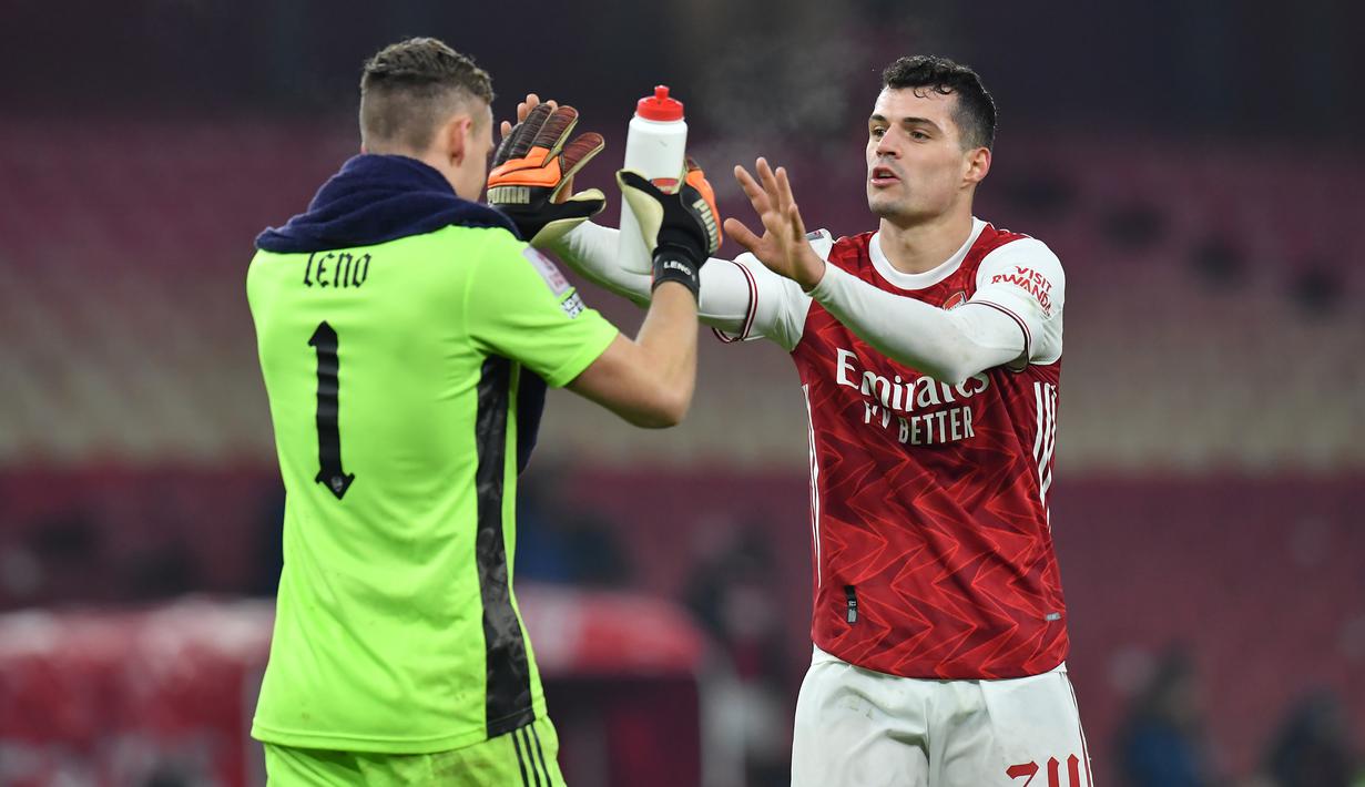 Bek Arsenal, Granit Xhaka (kanan) dan kiper Bernd Leno merayakan kemenangan 2-0 atas Newcastle United dalam laga babak ke-3 Piala FA 2020/21 yang harus diselesaikan melalui extra time di Emirates Stadium, Sabtu (9/1/2021). (AFP/Glyn Kirk/Pool)
