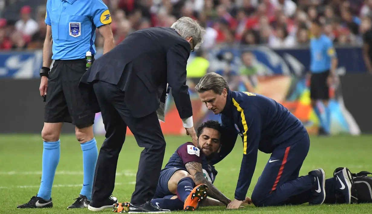 Petugas medis PSG memeriksa Daniel Alves saat laga Piala Prancis melawan Les Herbiers di Stade de France, Saint-Denis, (8/5/2018). Dani harus menjalani pemeriksaan ketat dari tim dokter Brasil. (AFP/Damien Meyer)