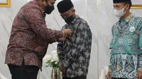 Yaqut Cholil Qoumas menyematkan pin Menteri Agama kepada pemenang Sayembara Santri Sehari Menjadi Menteri Agama Afi Ahmad Ridlo. (dok Kemenag)