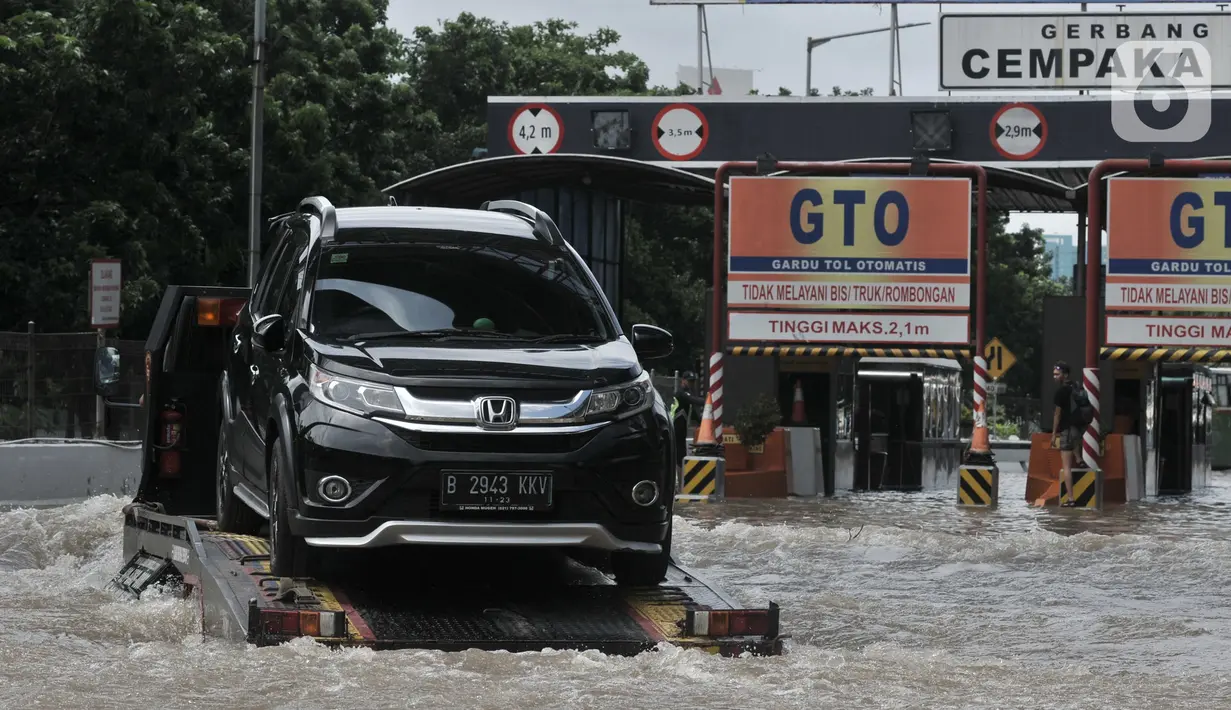 Sebuah mobil mogok diderek akibat nekat menerobos banjir di Tol Cempaka Putih, Jakarta, Minggu (23/2/2020). Banjir yang melanda kawasan tersebut menyebabkan Gerbang Tol Cempaka Putih tidak dioperasikan akibat terendam hingga ketinggian mencapai sepinggang orang dewasa. (merdeka.com/Iqbal S. Nugroho)
