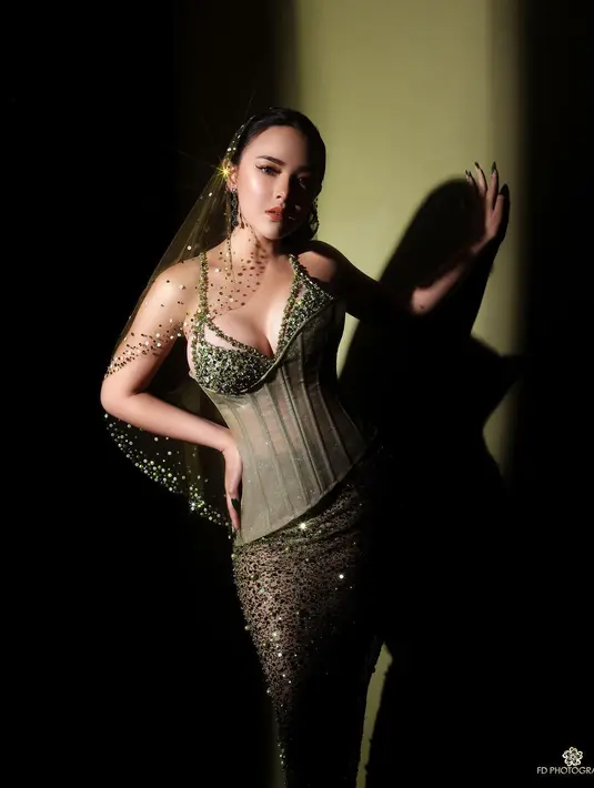 Dalam pemotretan bersama FD Photography, Amanda Manopo tampil berani dibalut gaun berpayet berwarna hijau dengan aksen bustier transparan rancangan Lisa Ju. [Instagram/fdphotography90]