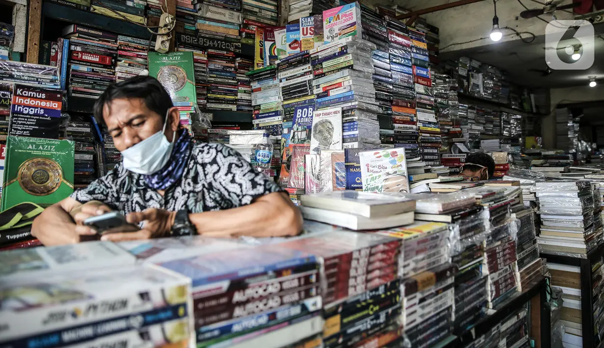 Pedagang menunggu pembeli buku di kawasan Kwitang Jakarta, Jumat (26/6/2020). Sejumlah pedagang mengaku penjualan buku mengalami penurunan hingga 50 persen karena imbauan Pemerintah untuk tinggal dirumah dan libur sekolah selama pandemi COVID-19. (Liputan6.com/Faizal Fanani)