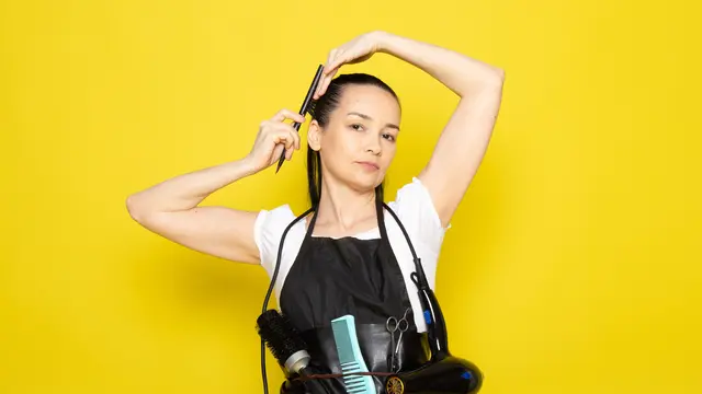 Seorang perempuan sedang melakukan styling terhadap rambutnya (Foto Dok: Freepik/KamranAydinov)