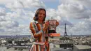 Petenis Polandia Iga Swiatek berpose dengan trofi juara Prancis Terbuka 2020 saat sesi foto di rooftop Galeries Lafayette, Paris, Prancis, Minggu (11/10/2020). Petenis berusia 19 tahun ini mencatatkan diri sebagai sosok Polandia pertama yang memenangkan Grand Slam. (AP Photo/Christophe Ena)