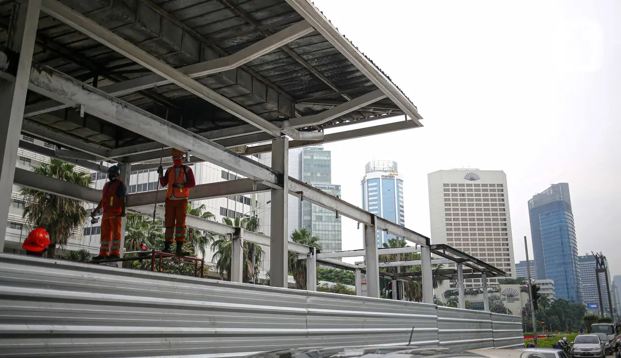 Pekerja menyelesaikan perbaikan Halte Transjakarta yang dibakar pasca aksi unjuk rasa di kawasan Bundara HI, Jakarta, Minggu (11/10/2020). Kerugian 46 halte bus rusak kerugiannya diperkirakan mencapai Rp 65 miliar. Perbaikan selesai diperkirakan 1 hingga 2 bulan. (Liputan6.com/Faizal Fanani)