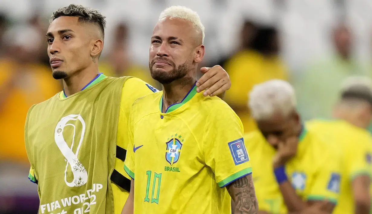 Pemain Brasil, Neymar (kanan) dihibur oleh rekannnya, Raphinha setelah tim mereka kalah dari Kroasia saat laga perempat final Piala Dunia Qatar 2022 yang berlangsung di Education City Stadium, Al-Rayyan, Jumat (09/12/2022) waktu setempat. Brasil kalah 2-4 dari Kroasia saat babak adu penalti. (AP/Darko Bandic)