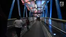 Warga melintasi jembatan penyeberangan orang (JPO) berhias lampu warna-warni di kawasan Jakarta Timur, Kamis (27/12).JPO ini memiliki struktur dan bentuk yang artistik dengan dihiasi lampu yang bisa berganti-ganti warna. (Merdeka.com/Imam Buhori)