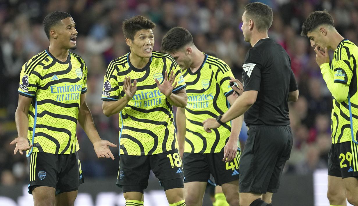 Bek Arsenal, Takehiro Tomiyasu (kedua kiri) berdebat dengan wasit setelah menerima kartu kuning saat menghadapi Crystal Palace pada laga pekan kedua Liga Inggris 2023/2024 di Selhurst Park, London (21/8/2023). (AP Photo/Kin Cheung)