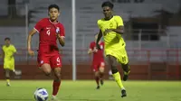 Pemain Singapura, Nizwan Herwan, berduel dengan penggawa Malaysia, Pavithran Gunalan (kanan) pada laga Piala AFF U-19 2024 di Stadion Gelora Tambaksari, Senin (22/7/2024). (Bola.com/Aditya Wany)