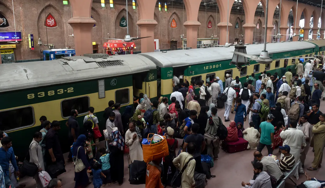 Para pelancong berebut memasuki pintu gerbong kereta saat mudik menuju kampung halaman untuk merayakan Idul Adha di stasiun Lahore, Pakistan, Sabtu (10/8/2019). Umat Islam di seluruh dunia merayakan Idul Adha yang identik dengan tradisi berkurban. (Photo by ARIF ALI / AFP)