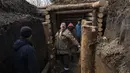 Seorang pria bercanda ketika dia bereaksi terhadap kamera saat membangun parit dengan tentara dan tetangga, di Lityn, Ukraina, Rabu, 16 Maret 2022. Invasi Rusia ke Ukraina memasuki hari ke-21. (AP Photo/Rodrigo Abd)