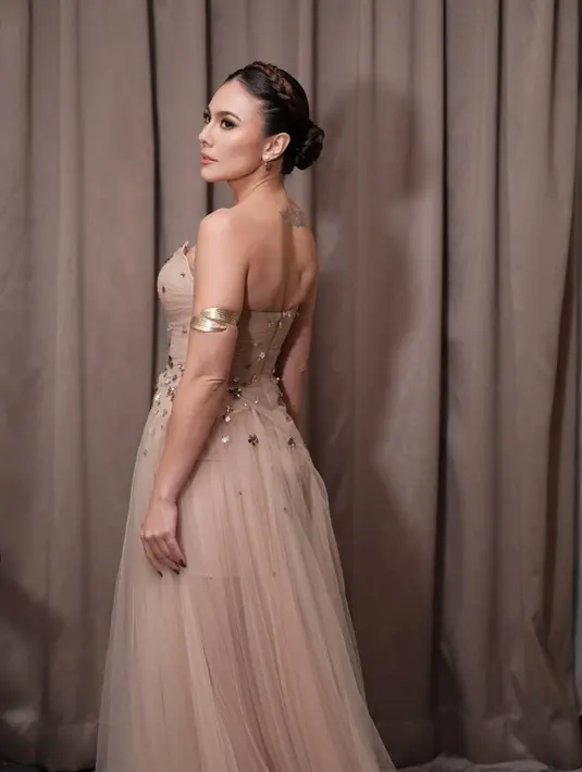 Dress tanpa tali ini mengekspos tato tipis Wulan Guritno yang ada di punggung bagian tengah [@wulanguritno]