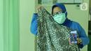 dr. Nurul Hidayah (34) menunjukkan foto ibunya saat di RSUD Pasar Minggu, Jakarta, Jumat (22/5/2020). Nurul Hodayah sudah 3 bulan tidak bertemu keluarga selama bertugas menjaga COVID -19 di RSUD Pasar Minggu. (Liputan6.com/Herman Zakharia)