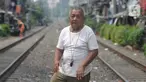 Penjaga perlintasan kereta api tanpa palang pintu, Wandi, menjaga perlintasan di Kawasan Petamburan, Jakarta, Jumat (4/6/2021). Sudah 10 tahun, Bapak Wandi menjaga palang pintu perlintasan kereta api yang kerap dilintasi oleh  pengguna jalan untuk menyeberang. (merdeka.com/Imam Buhori)