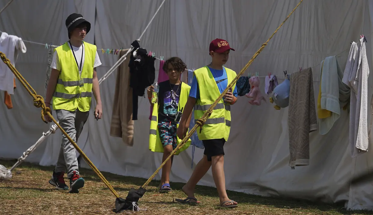 <p>Anak-anak pengungsi Ukraina berjalan melalui sebuah kamp di Parque Utopia, di wilayah Iztapalapa di Mexico City, Selasa (24/5/2022). Mexico City akan menutup kamp yang telah menampung ratusan pengungsi Ukraina selama sebulan terakhir setelah program AS mengizinkan mereka terbang ke Negeri Paman Sam sudah beroperasi dan pihak berwenang mengatakan kamp itu tidak lagi diperlukan. (AP/Marco Ugarte)</p>