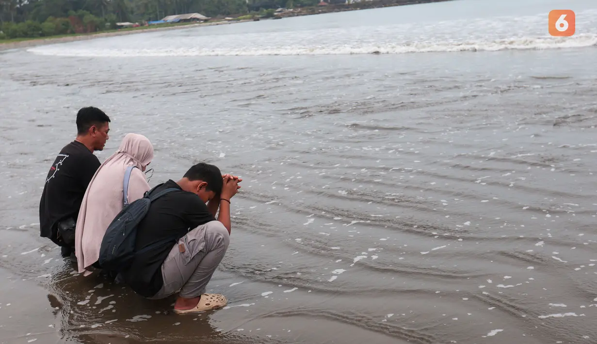 Suasana haru keluarga saat mengikuti prosesi tabur bunga untuk lima jurnalis dan tiga kru kapal Arupadhatu 1 di pantai dekat Dermaga Pegedongan, Banten, Jumat (18/9/2026). Sejumlah keluarga terlihat menangis setelah operasi pencarian delapan orang tersebut dihentikan Tim SAR Gabungan. (KLY/Budy Santoso)