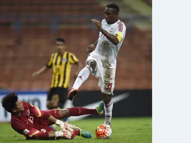 Kiper Malaysia, Mohd Izham Tarmizi, berusaha menahan bola tendangan pemain UEA, Ahmed Khalil, dalam Kualifikasi Piala Dunia 2018 di Stadion Shah Alam, Malaysia, (17/11/2015). Malaysia kalah 1-2 dari UEA. (AFP Photo/Manan Vatsyayana)