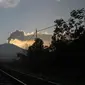 Warga melihat Gunung Raung mengeluarkan awan panas yang terlihat dari Kabupaten Jember, Jawa Timur, Minggu (12/7/2015). Gunung Raung terus menunjukkan aktivitas vulkaniknya dan menyebabkan terjadi hujan abu tipis di sejumlah wilayah. (AFP PHOTO)