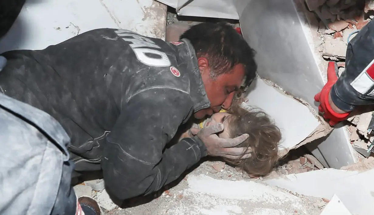 Petugas penyelamat memegang Ayda Gezgin, 3, yang terjebak reruntuhan gedung apartemen setelah gempa bumi dahsyat di kota Izmir, Turki, Selasa (3/11/2020). Ayda Gazgin berhasil diselamatkan dari bawah reruntuhan bangunan setelah terkubur selama 4 hari atau sekitar 91 jam. (AFAD via AP)