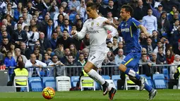 Penyerang Real Madrid, Cristiano Ronaldo, menggiring bola melewati pemain Getafe pada laga La Liga di Stadion Santiago Bernabeu, Spanyol, Sabtu (5/12/2015). (EPA/J.P. Gandul)
