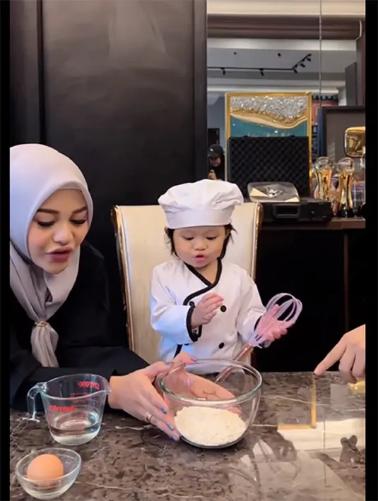 'Fun cooking with chef cilik Ameena', Ameena memasak pancake lezat dan gampang dibuat. Momen lucu dan menggemaskan ketika Aurel Hermansyah mengenalkan bahan-bahan kue di depan baby Ameena. Ada tepung, air hingga telur bulat. [Instagram/attahalilintar]