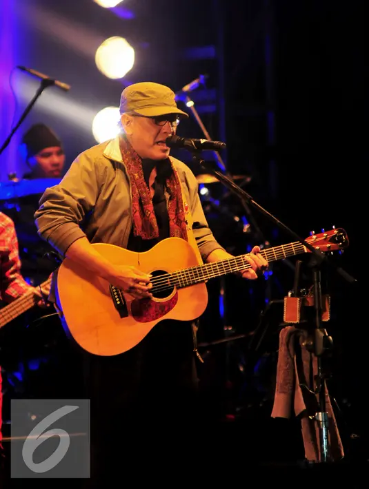 Iwan Fals memainkan gitarnya sambil bernyanyi dalam konser bertajuk Untukmu Indonesia di Istora Senayan, Jakarta, Sabtu (21/11). Iwan Fals membawakan sebanyak 23 lagu pada konser tersebut. (Liputan6.com/Faisal R Syam)