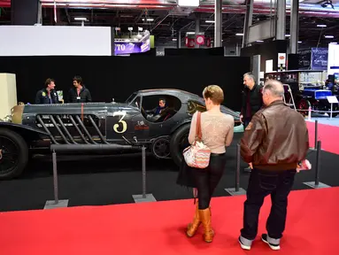 Pengunjung melihat mobil tua yang ditampilkan selama pameran mobil klasik Retromobile di Porte de Versailles, di Paris (4/2/2020). Retromobile berlangsung dari 5 Februari hingga 9 Februari 2020. (AFP Photo/Martin Bureau)